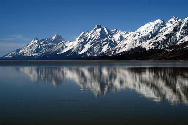 Snowy Teton Mountain Range reflected in a lake.