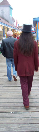 A mysterious man walks along a boardwalk